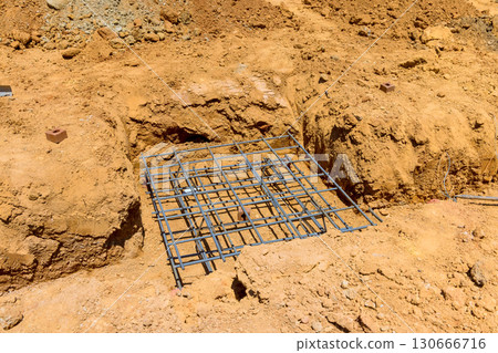 Workers utilize rebar mesh within trench at construction site during works day Workers utilize rebar mesh within trench at construction site during works day 130666716