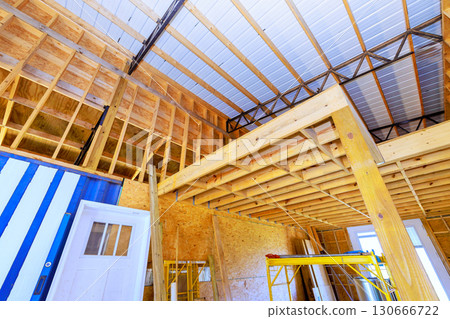 Construction underway inside building, wooden beams scaffolding in construction zone 130666722