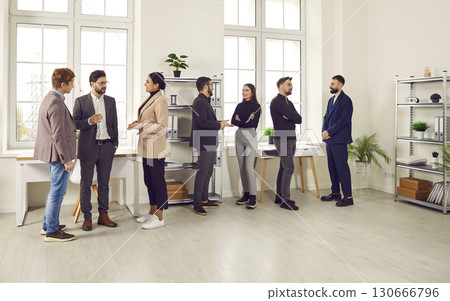 Young men and women communicating and discussing work at a business meeting in the office Young men and women communicating and discussing work at a business meeting in the office 130666796