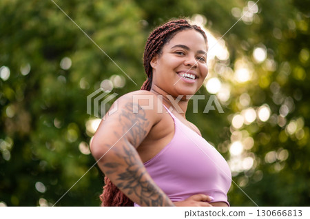 African American woman in sportswear posing on outdoor sportsground 130666813