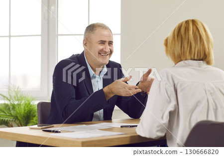Bank manager, credit agent or loan broker meeting with woman and offering her deal Bank manager, credit agent or loan broker meeting with woman and offering her deal 130666820