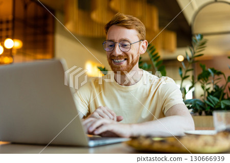 Bearded man working on laptop having pizza for dinner Bearded man working on laptop having pizza for dinner 130666939
