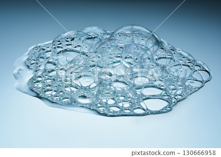 The texture of soap bubbles and foam in close-up on a blue background. The texture of soap bubbles and foam in close-up on a blue background. 130666958