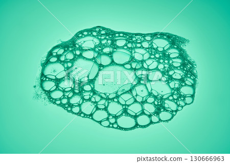 The texture of soap bubbles and foam in close-up on a green background. The texture of soap bubbles and foam in close-up on a green background. 130666963