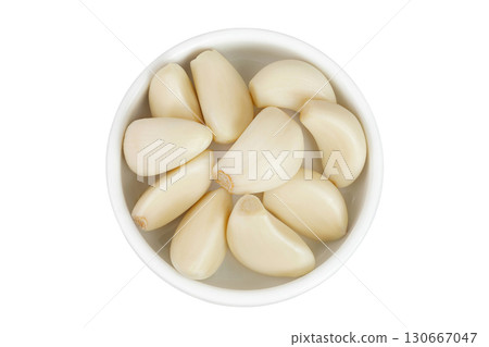 garlic cloves in ceramic bowl isolated on white background close up. Top view. Flat lay. garlic cloves in ceramic bowl isolated on white background close up. Top view. Flat lay. 130667047