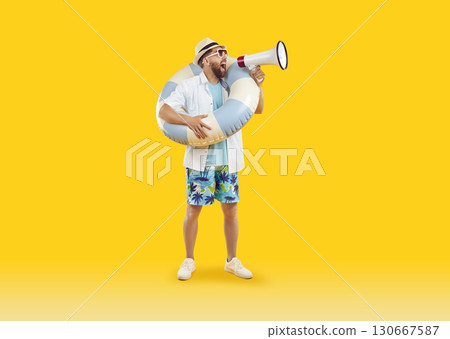 Young man tourist screaming with mouthpiece on studio yellow background. Vacation trip concept. 130667587