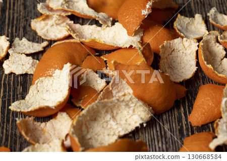 peel of peeled oranges on the table, a large amount of peel of peeled citrus fruits on the table, close up peel of peeled oranges on the table, a large amount of peel of peeled citrus fruits on the table, close up 130668584