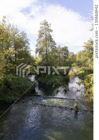 river with trees during leaf fall, a bright autumn landscape with a river and trees on the shore in the autumn season river with trees during leaf fall, a bright autumn landscape with a river and trees on the shore in the autumn season 130668642