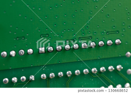 a printed circuit board with an electronic circuit with soldered elements, close up 130668652