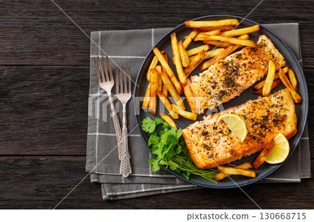Baked salmon fillet with french fries on plate 130668715