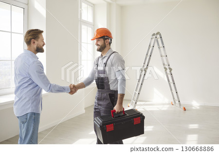Professional construction worker and man client confirming agreement about house renovation Professional construction worker and man client confirming agreement about house renovation 130668886