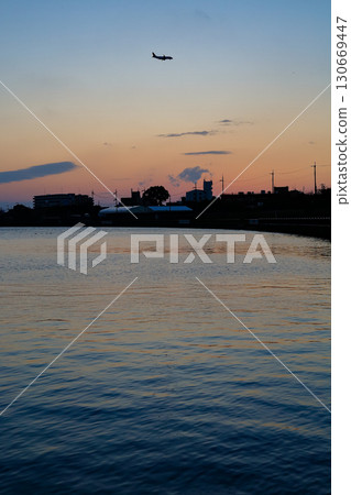 水面上映照的夕陽與飛機的影子交相輝映 130669447