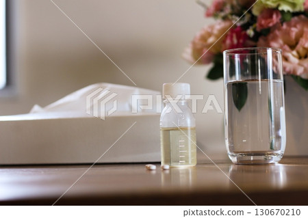 紙巾、一杯水、一個糖漿容器、一張服藥的圖片、鮮花 130670210