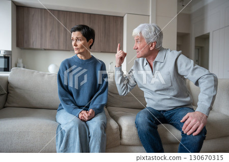 Irate shouting husband with hysterical behavior in toxic argument, undermining woman reality 130670315