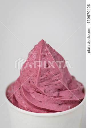Vibrant pink berry soft serve in white cup, close-up shot on light background Vibrant pink berry soft serve in white cup, close-up shot on light background 130670408