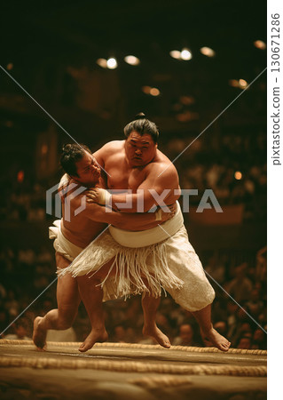 Sumo wrestlers engage in intense duel during traditional competition in Japan 130671286