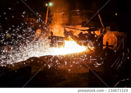 Molten iron stream in a steel mill. Molten iron stream in a steel mill. 130671329