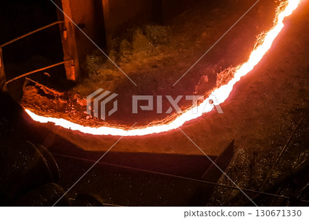 Molten iron stream in a steel mill. Molten iron stream in a steel mill. 130671330