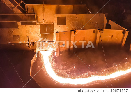 Molten iron stream in a steel mill. Molten iron stream in a steel mill. 130671337
