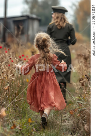 Five year old girl joyfully runs to hug her mother in military uniform during a joyful reunion 130671834