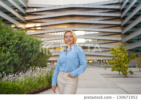 Confident young blond businesswoman standing 130671952