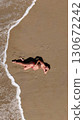 Pregnant Woman Relaxing by the Ocean Aerial Beach Photography 130672242