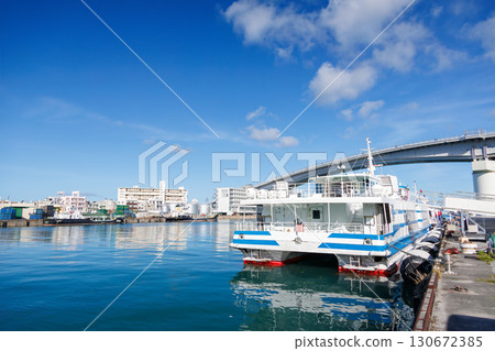 This is the Marine Liner Tokashiki, a high-speed jet ferry bound for Tokashiki Island in the Kerama Islands. Tomari Bridge can be seen in the background. 130672385