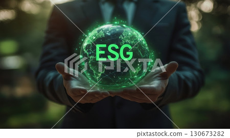 Business professional holding a glowing green globe representing environmental, social, and governance principles outdoors 130673282