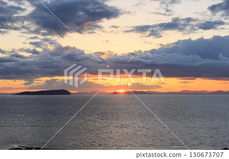 Sunset over the Seto Inland Sea seen from Mount Kotohiki in Kannonji City, with the sun setting over Ibukijima, Enjojima and the islands of Kamijima Town, Ehime Prefecture 130673707
