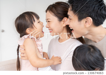 Parent and daughter, family of four, girl opening her mouth Parent and daughter, family of four, girl opening her mouth 130674063