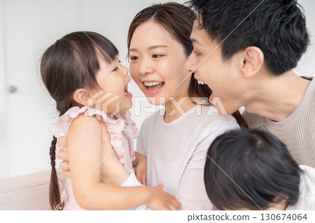 Parent and daughter, family of four, girl opening her mouth 130674064