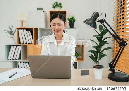 happy woman working with laptop computer at home office happy woman working with laptop computer at home office 130674305