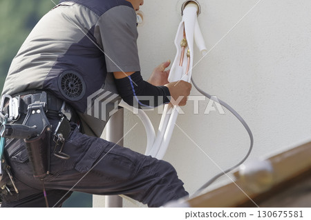 Workers installing air conditioners at high altitudes 130675581