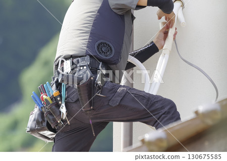 Workers installing air conditioners at high altitudes 130675585