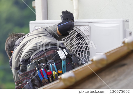 Workers installing air conditioners at high altitudes Workers installing air conditioners at high altitudes 130675602