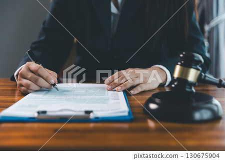 Justice and lawfirm concept. Female lawyer in office with brass scale. Woman hand gavel to bang. Law and justice trial session. Business lawyer notary stamping agreement, company secretary, validity. Justice and lawfirm concept. Female lawyer in office with brass scale. Woman hand gavel to bang. Law and justice trial session. Business lawyer notary stamping agreement, company secretary, validity. 130675904