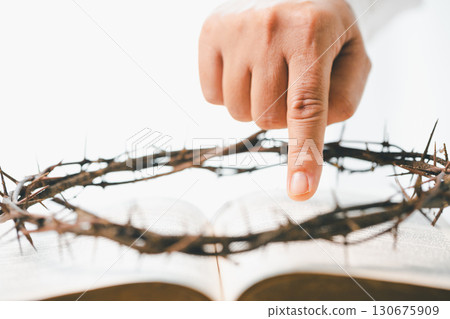Crown of cross with hand. Crown of thorns on head and hands nailed to cross, Jesus Christ made ultimate sacrifice, symbolizing faith, belief and profound religious and spiritual meaning of Easter. 130675909