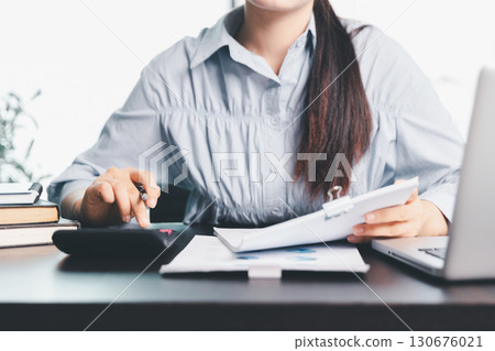 Business woman analyze calculate company financial, tax results office accounting statistics analytical research. calculating business balance prepare tax reduction. Tax deduction planning concept. 130676021