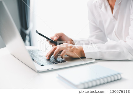 Close-up businesswoman using smart mobile phone at office table, female student is home studying online e-learning, searching for information on internet, engaging with social networks. 130676118