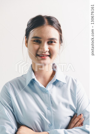 Asian woman rejoicing, looking happy, champion, fist pump gesture, standing over white background. young woman had happy, positive expression on her face, highlighted by bright smile. 130676161