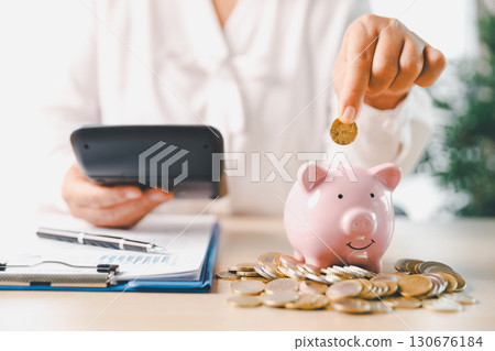 Businesswoman focused on saving money, smart financial planning, using banking, investment strategies to grow business, build wealth, achieve success while contributing to overall economy growth. 130676184