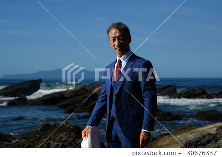 海邊一位穿著西裝的花花公子中年男子的畫像 130676337