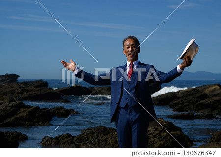 Portrait of a dandy middle-aged man in a suit at the sea 130676347