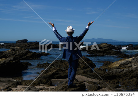 海邊一位穿著西裝的花花公子中年男子的畫像 130676354