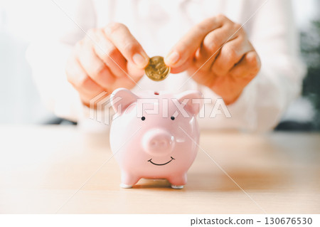 Businesswoman focused on saving money, smart financial planning, using banking, investment strategies to grow business, build wealth, achieve success while contributing to overall economy growth. 130676530
