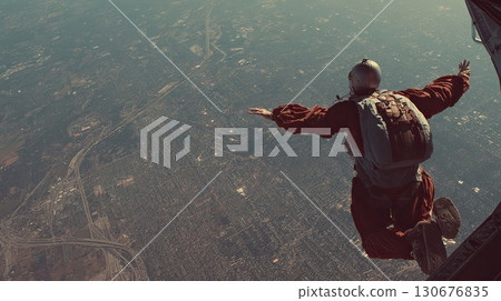 Skydiver is flying over landscape with clouds and mountains 130676835