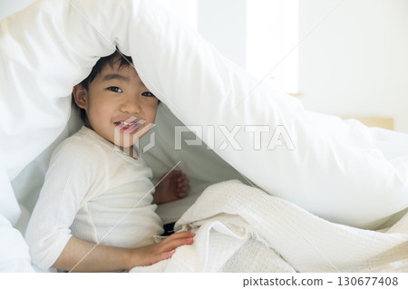 Toddler lying on bed 130677408
