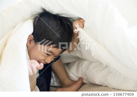 Toddler lying on bed 130677409