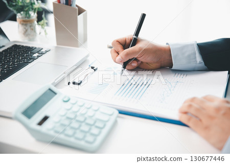 Accountant working on desk using calculator for calculate finance report in office. business finance, calculate tax by organizing financial documents, tracking income investment, accounting by hand. Accountant working on desk using calculator for calculate finance report in office. business finance, calculate tax by organizing financial documents, tracking income investment, accounting by hand. 130677446