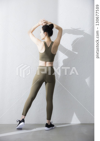 一個穿著訓練服伸展的女人 130677589